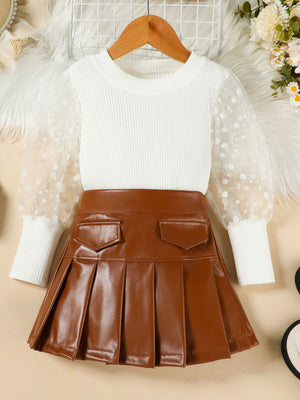 White ribbed top with polka dot sheer sleeves and brown faux leather pleated skirt.