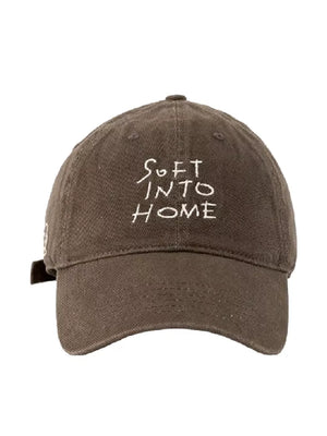 Brown cotton baseball cap with white embroidered text SOFT INTO HOME