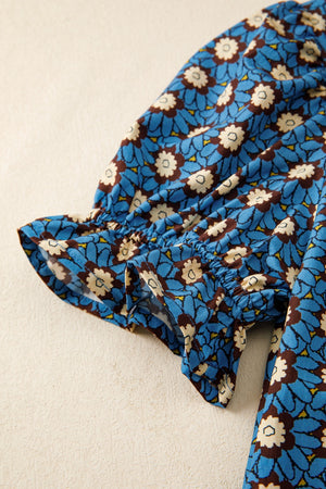 Floral V-neck puff sleeve blouse in blue with white and brown floral print and ruffled cuffs.