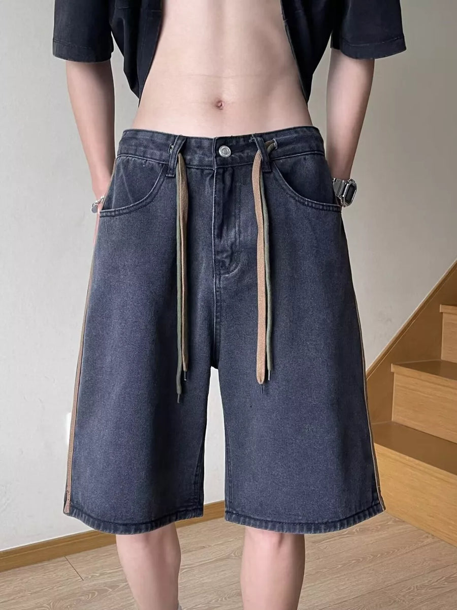 Men's dark wash wide-leg denim shorts with colorful drawstring and side stripe detail.