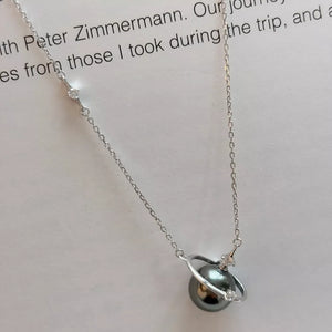 Celestial pearl and silver pendant necklace with delicate cubic zirconia accents.