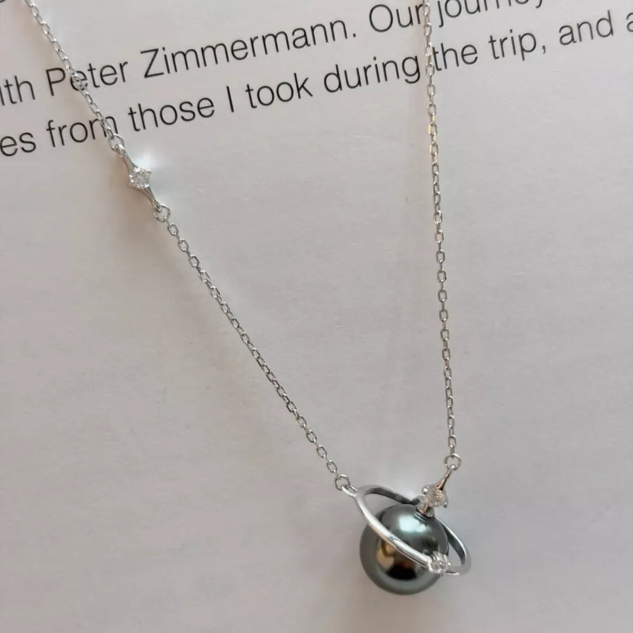 Celestial pearl and silver pendant necklace with delicate cubic zirconia accents.