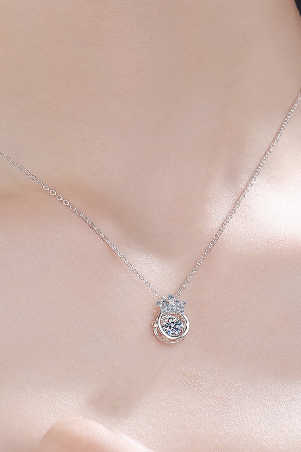 Silver pendant necklace with a crown and a sparkling center stone.