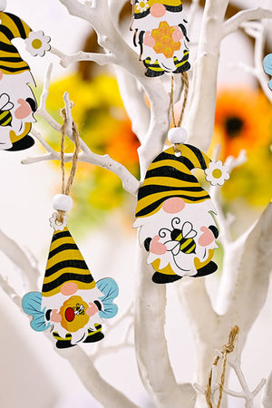 Yellow and black bee gnome ornaments with wings and flowers, hanging on a white branch.