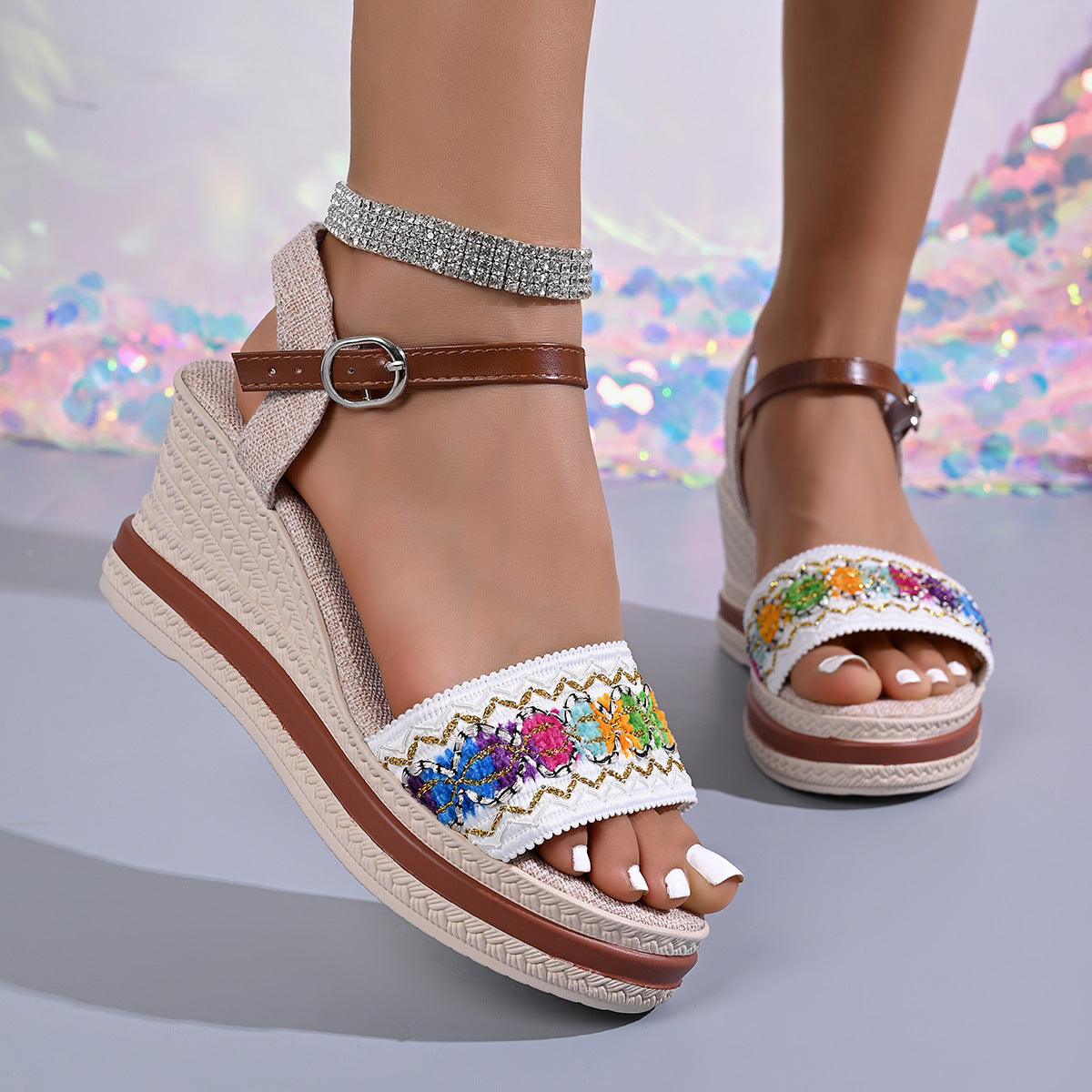 Embroidered floral wedge sandals in gray/white with adjustable strap and brown buckle.