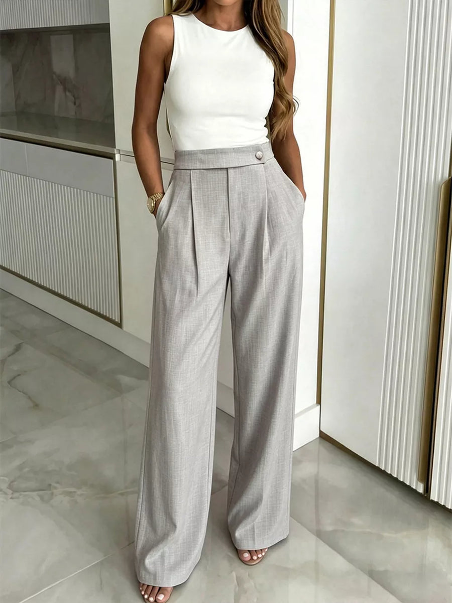 Gray high-waisted wide-leg pleated trousers with button closure and pockets.