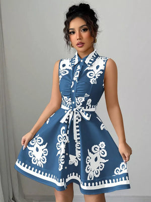 Dusty blue a-line dress with white pattern, collared, sleeveless, button-down, and tie waist.