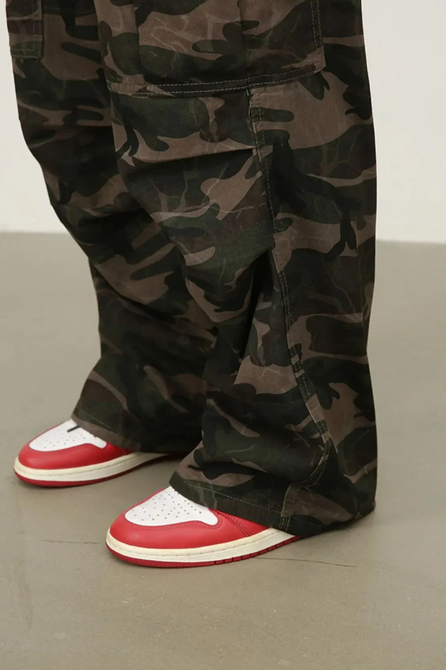 Wide-leg camo cargo trousers in green camouflage pattern with large cargo pockets.