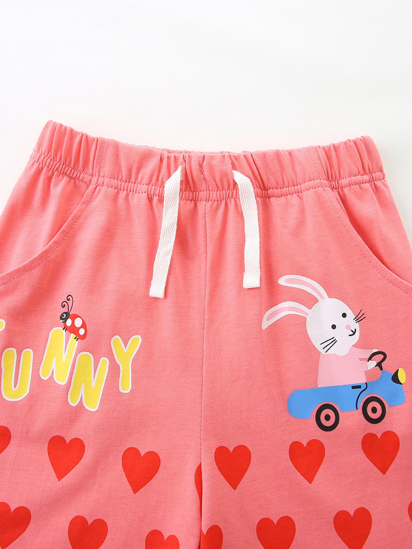 Pink cotton toddler shorts with bunny, ladybug, and heart print.
