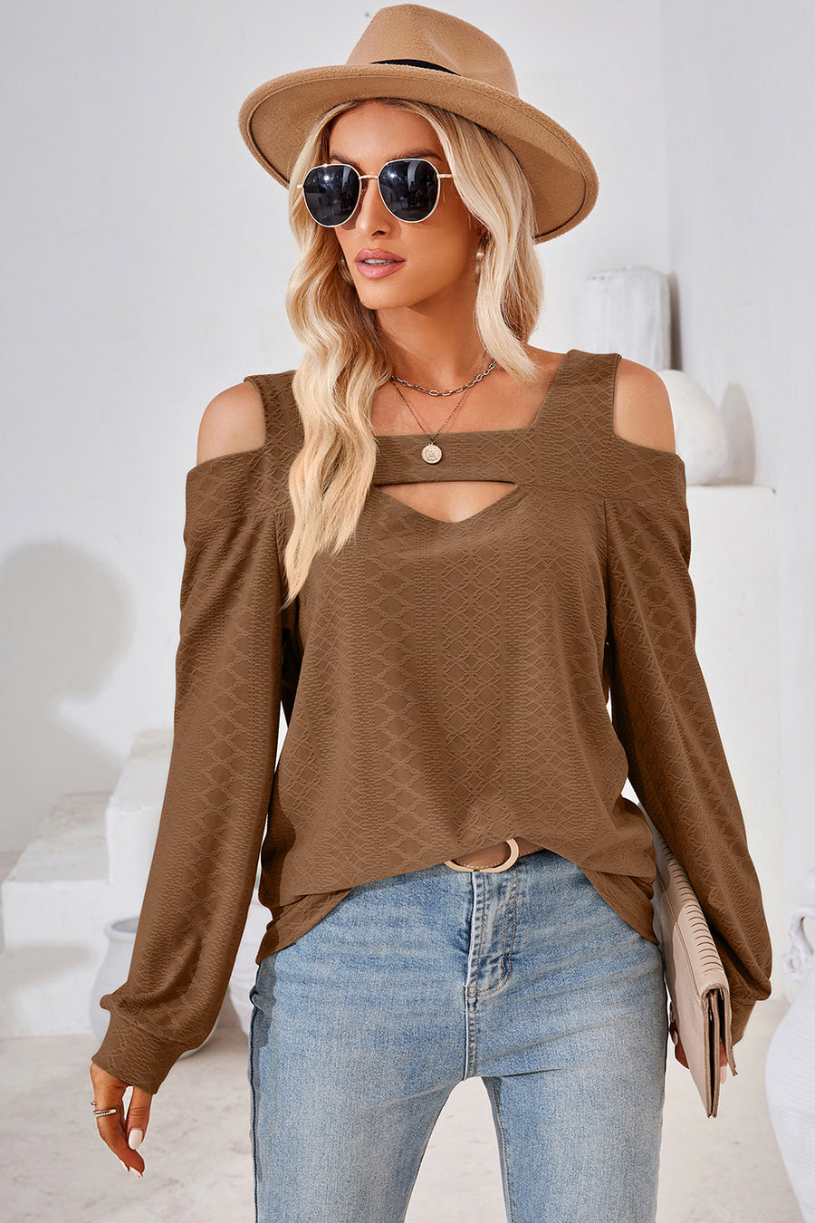Brown geometric cutout shoulder top with a v-neck and long sleeves.