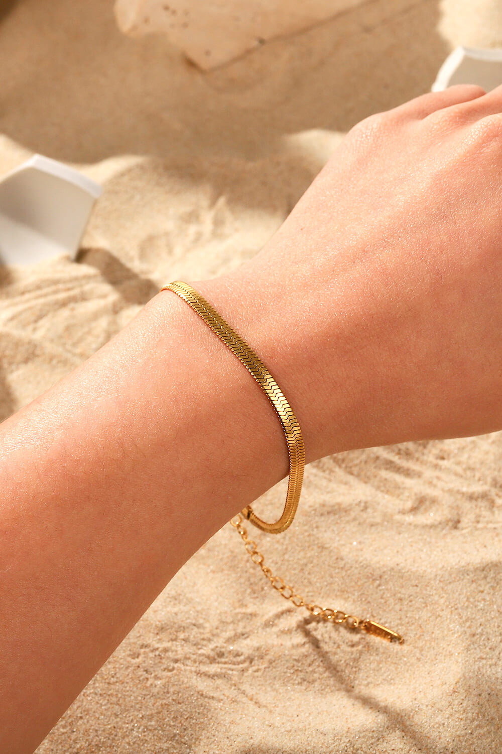 Golden serpent herringbone chain bracelet with adjustable clasp detail.