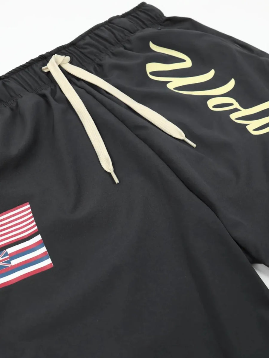 Black active shorts with drawstring and Wolves script logo, featuring a flag patch.