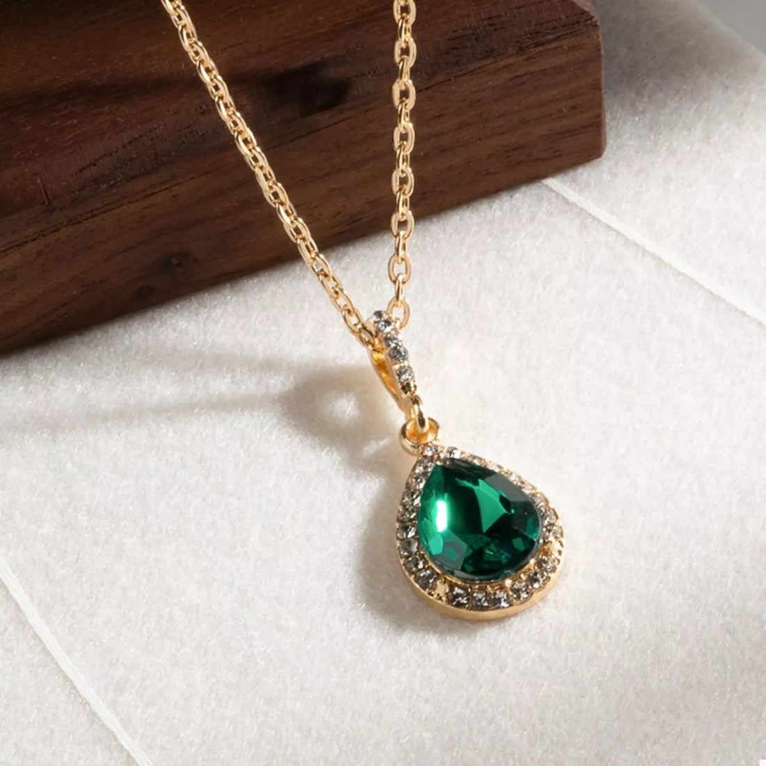 18K gold-plated necklace with dark green teardrop crystal pendant surrounded by small clear crystals.