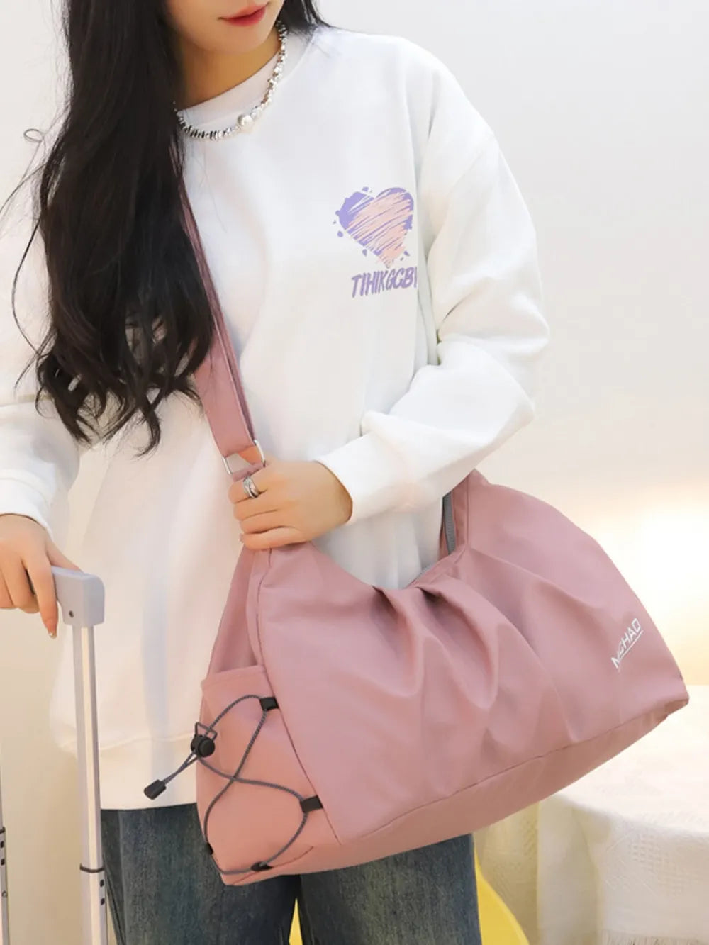 Dusty Pink gathered pleat crossbody bag with adjustable strap and drawstring side pockets.