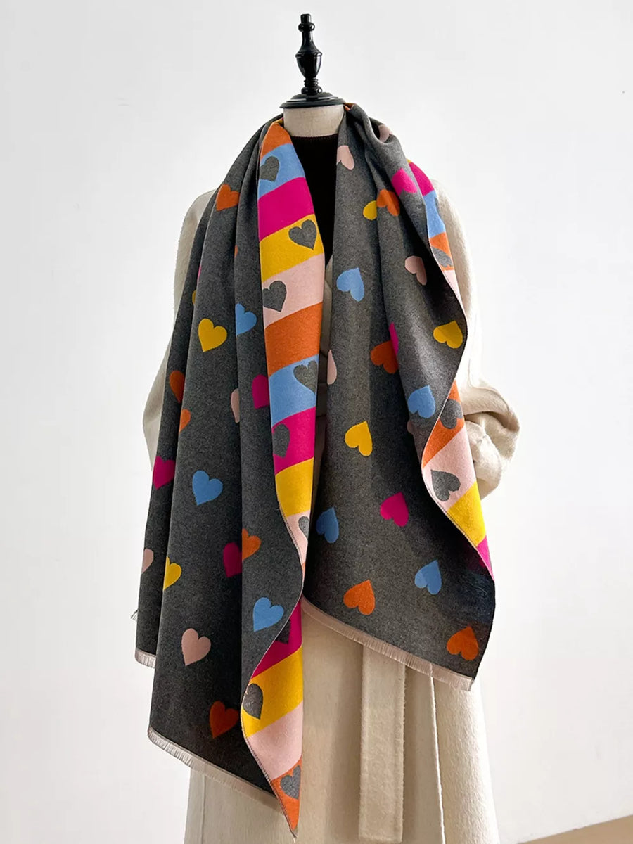 Gray scarf with multicolor heart pattern and striped border, fringed edges.