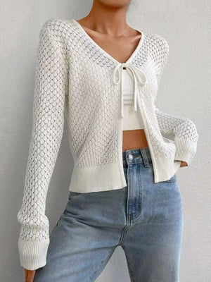 White openwork knit cardigan with tie-front detail and long sleeves.