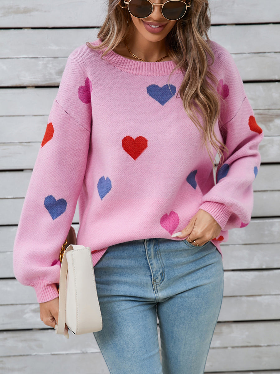 Pink acrylic knit sweater with bubble sleeves and a scattered heart motif.