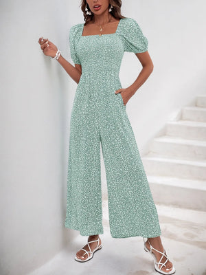 Light green floral print smocked bodice jumpsuit with puff sleeves and wide legs.