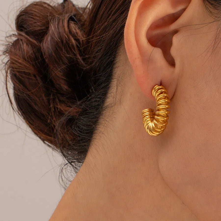 Gold vermeil spiral coil hoop earrings with a textured finish.
