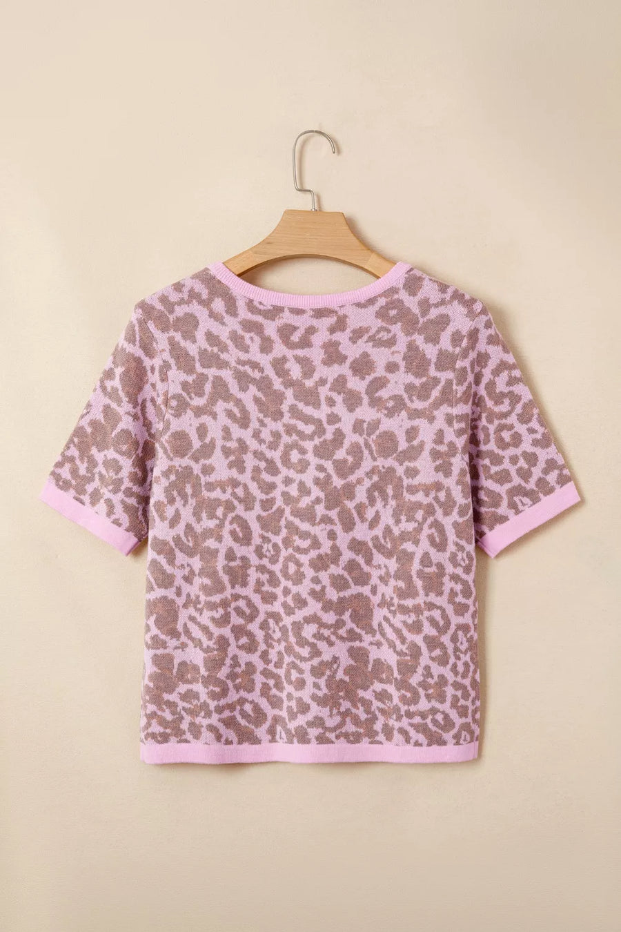 Pink leopard print knit cardigan with short sleeves and crew neck.