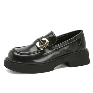 Black patent leather chunky loafers with gold buckle detail and platform sole.