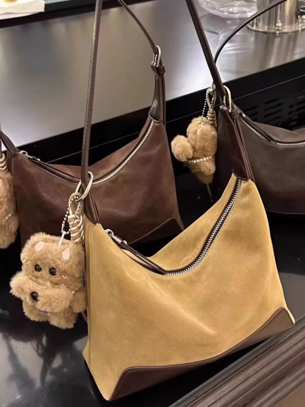 Taupe suede shoulder bag with adjustable strap and teddy bear charm