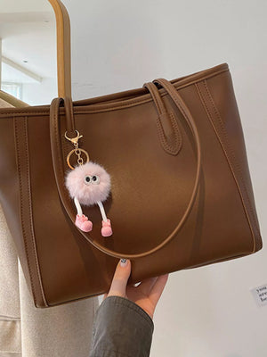 Brown PU leather tote bag with a fluffy pink charm and pink shoes.
