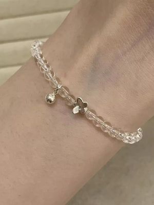 Crystal bead bracelet with silver butterfly charm and bell detail.