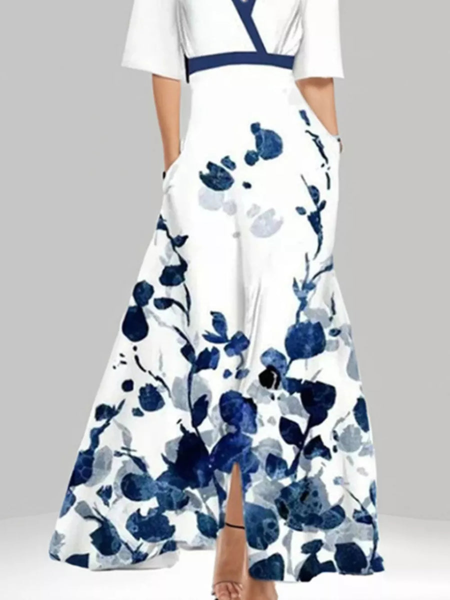 White maxi dress with blue floral print, pockets, and a defined waist.