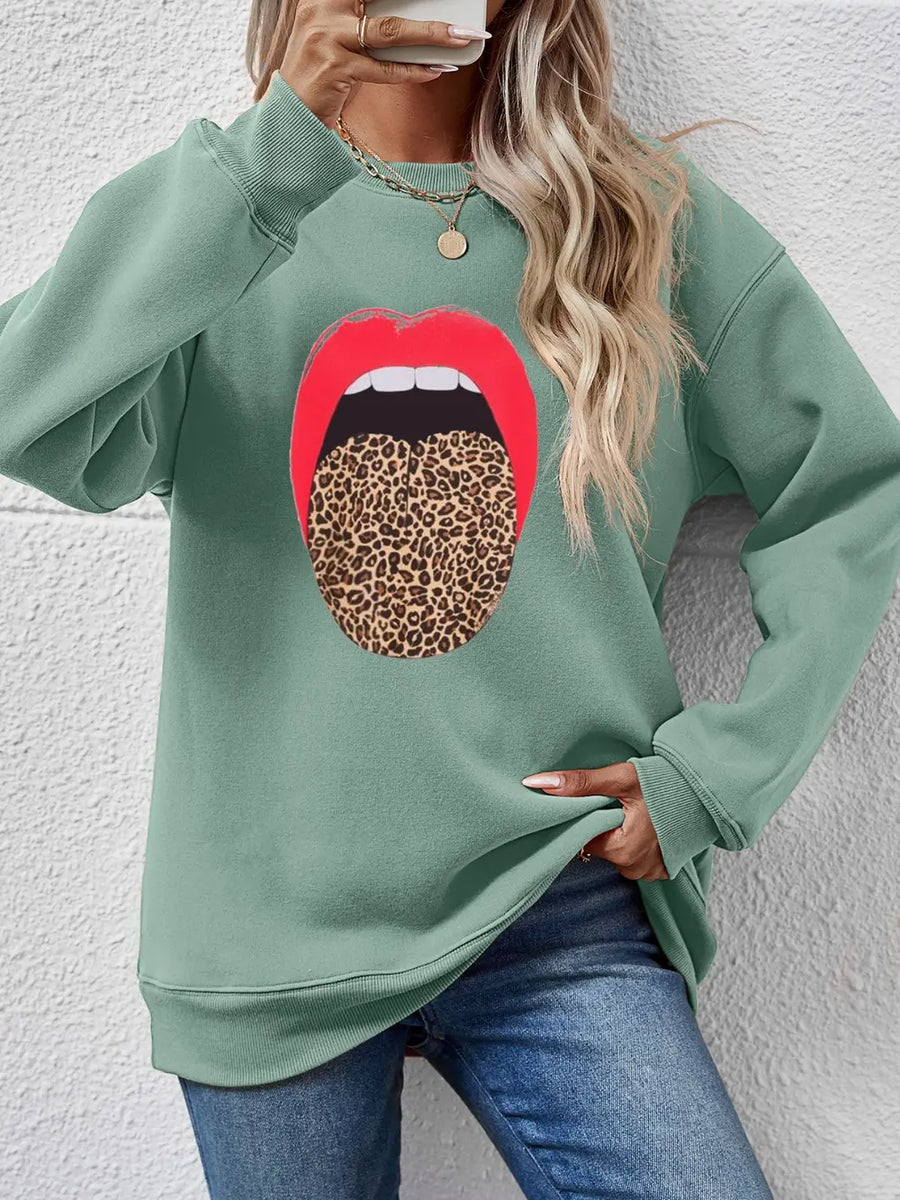Sage green sweatshirt with a bold red lips and leopard tongue graphic.