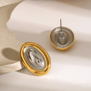 Gold two-tone oval statement earrings with a polished finish and textured center.