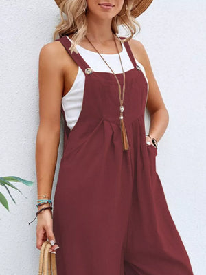Burgundy wide-leg romper with pockets and button straps, styled with a white tank top.