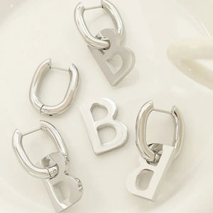 Silver titanium statement hoop earrings with bold letter charms