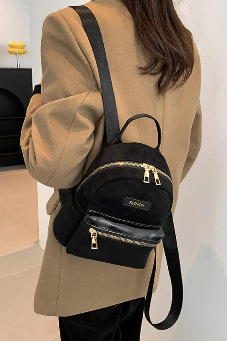 Black suede mini backpack with golden zips and "Fashion" detail