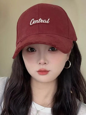 Baseball cap in maroon with embroidered "Central" text and distressed brim.