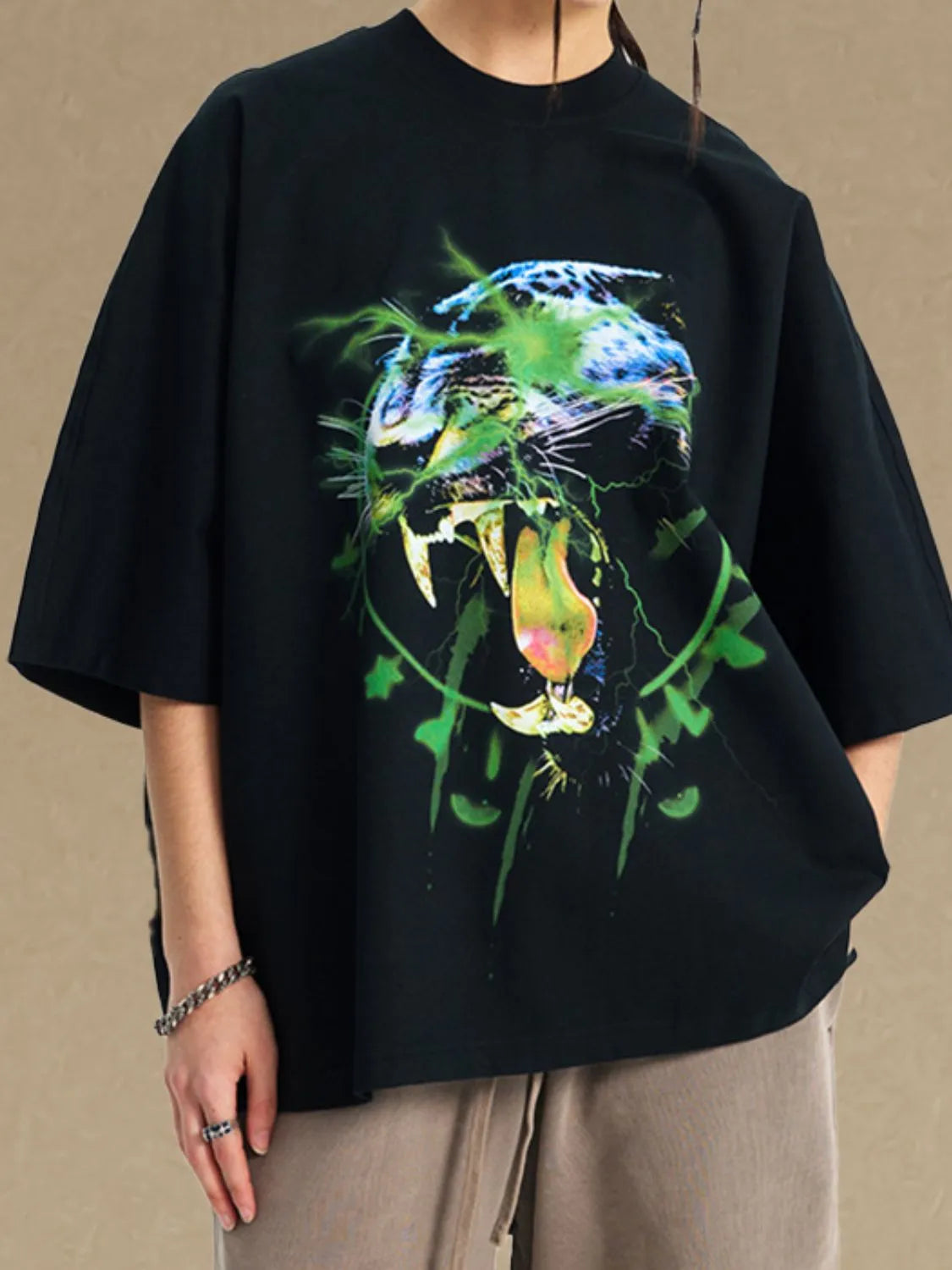 Black oversized tee with a bold electric leopard graphic print and short sleeves.