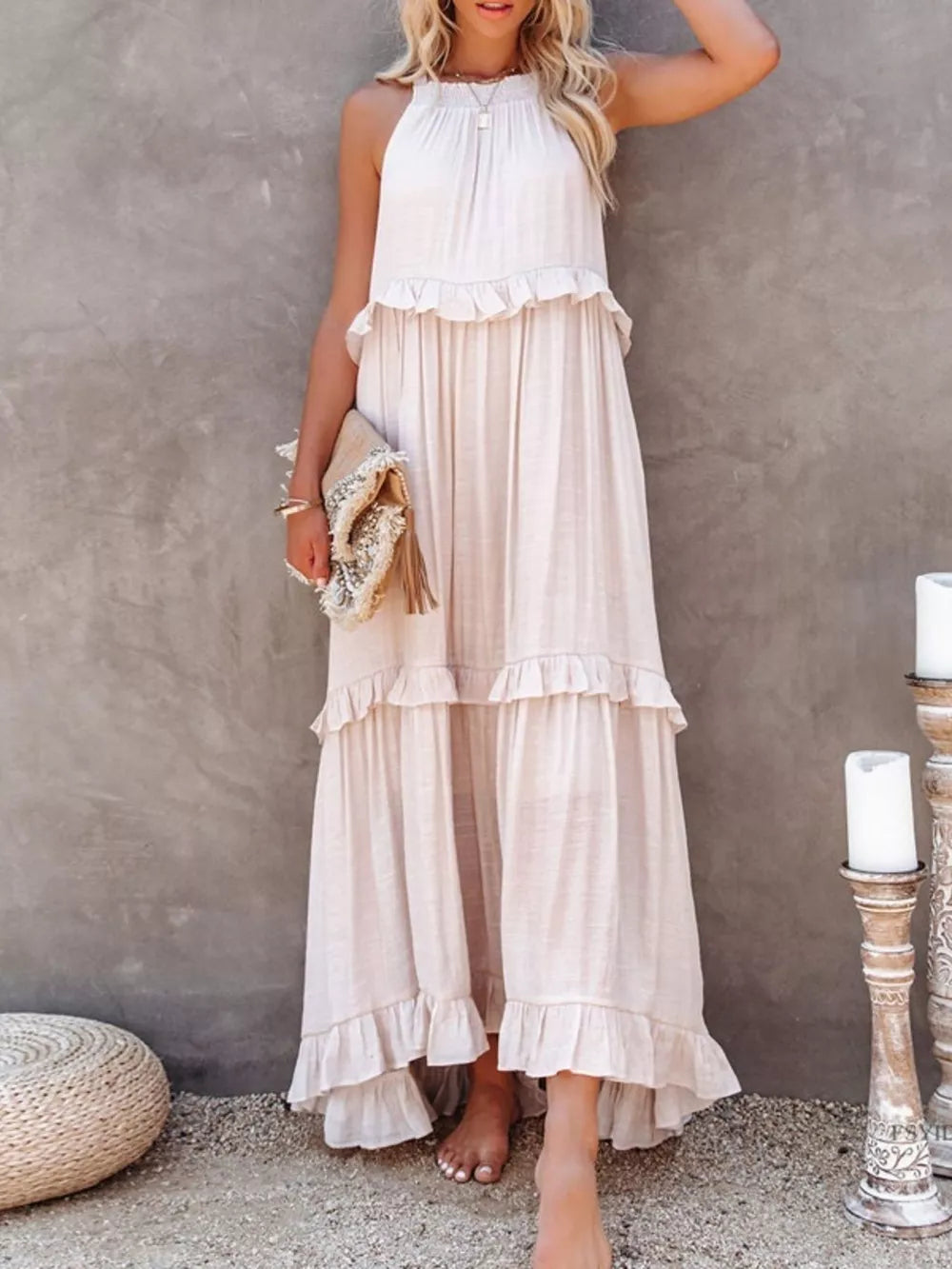 White ruffled maxi dress with halter neck and tiered skirt.