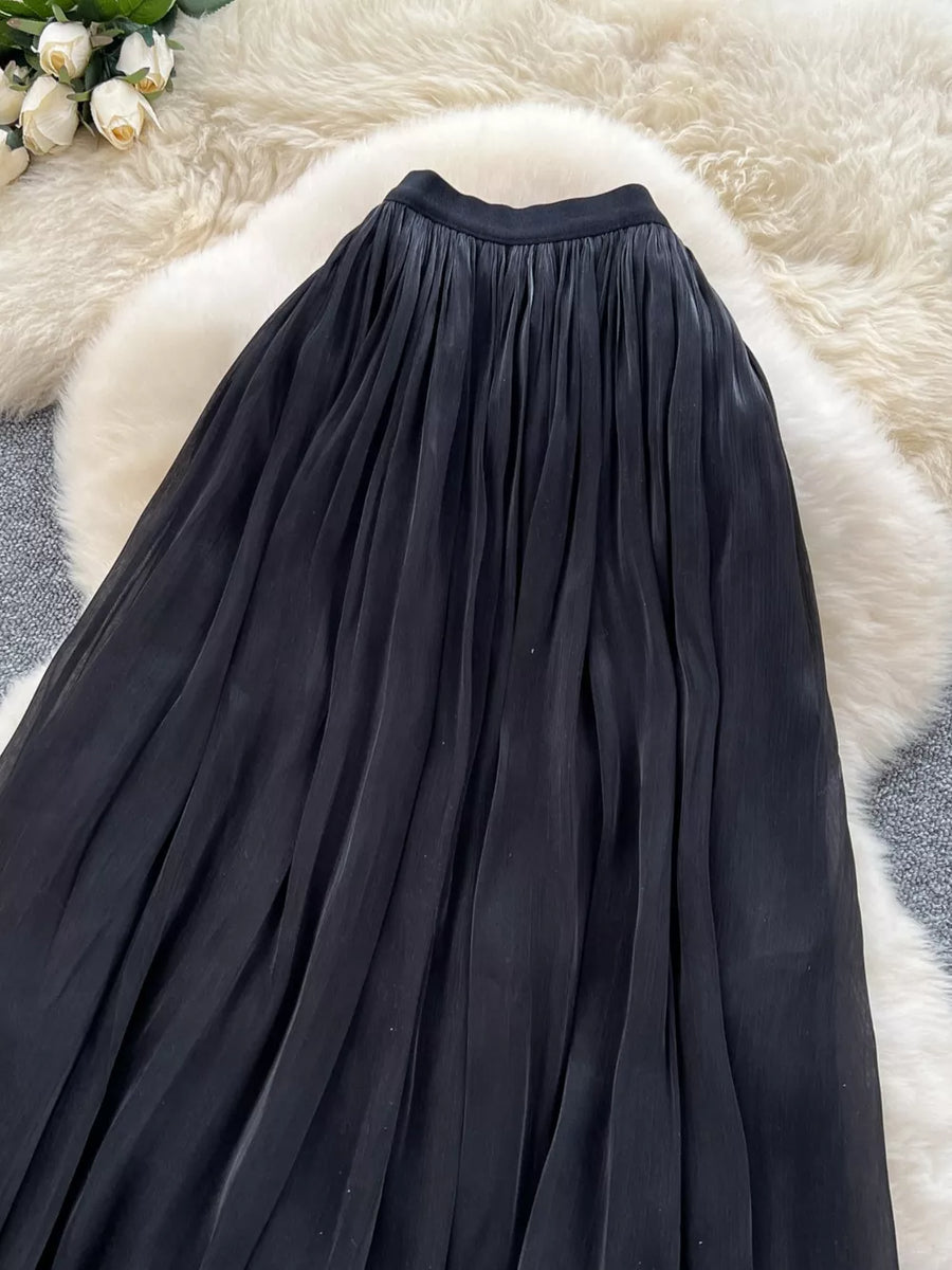 Black pleated maxi skirt with a flowy, elegant cut.