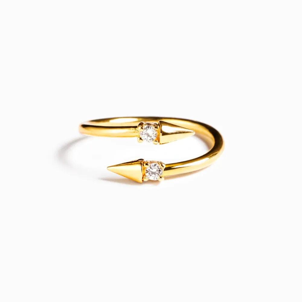 Gold bypass ring with two spiked ends, each set with a clear zirconia stone.