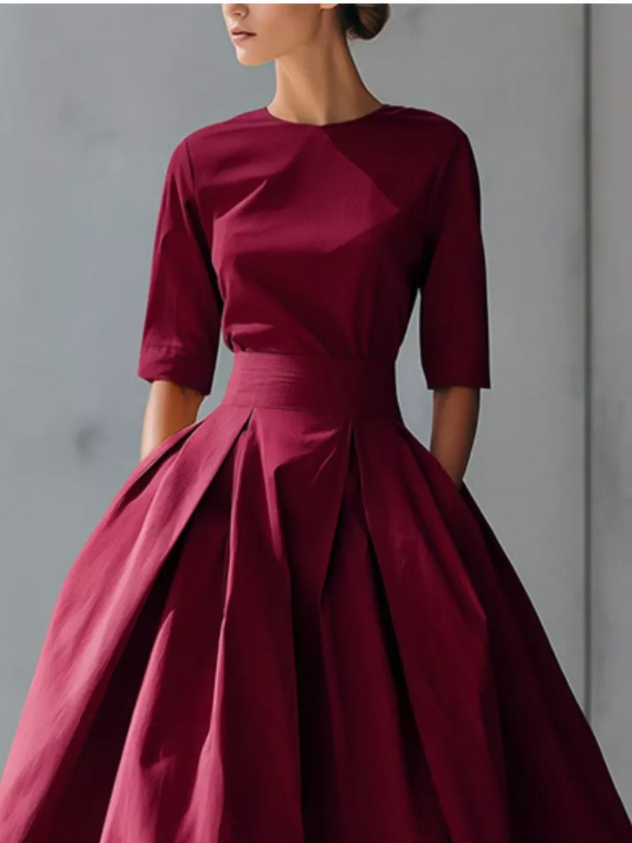 Burgundy A-line midi dress with pleated skirt and three-quarter sleeves.