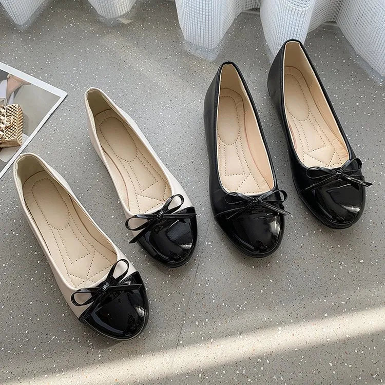 Patent bow ballet flats in black and white with a cap toe detail.