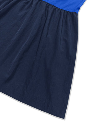 Three-tone wide strap dress in blue and navy with a gathered waist and flowy skirt.