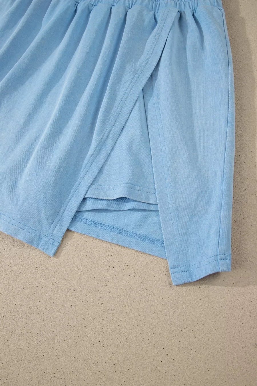 Light blue cotton skort with a wrap-style overlay and elastic waistband detail.