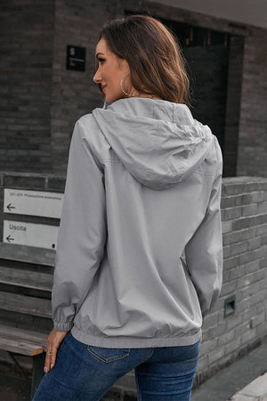 Light gray hooded utility jacket with drawstring waist and elastic cuffs.
