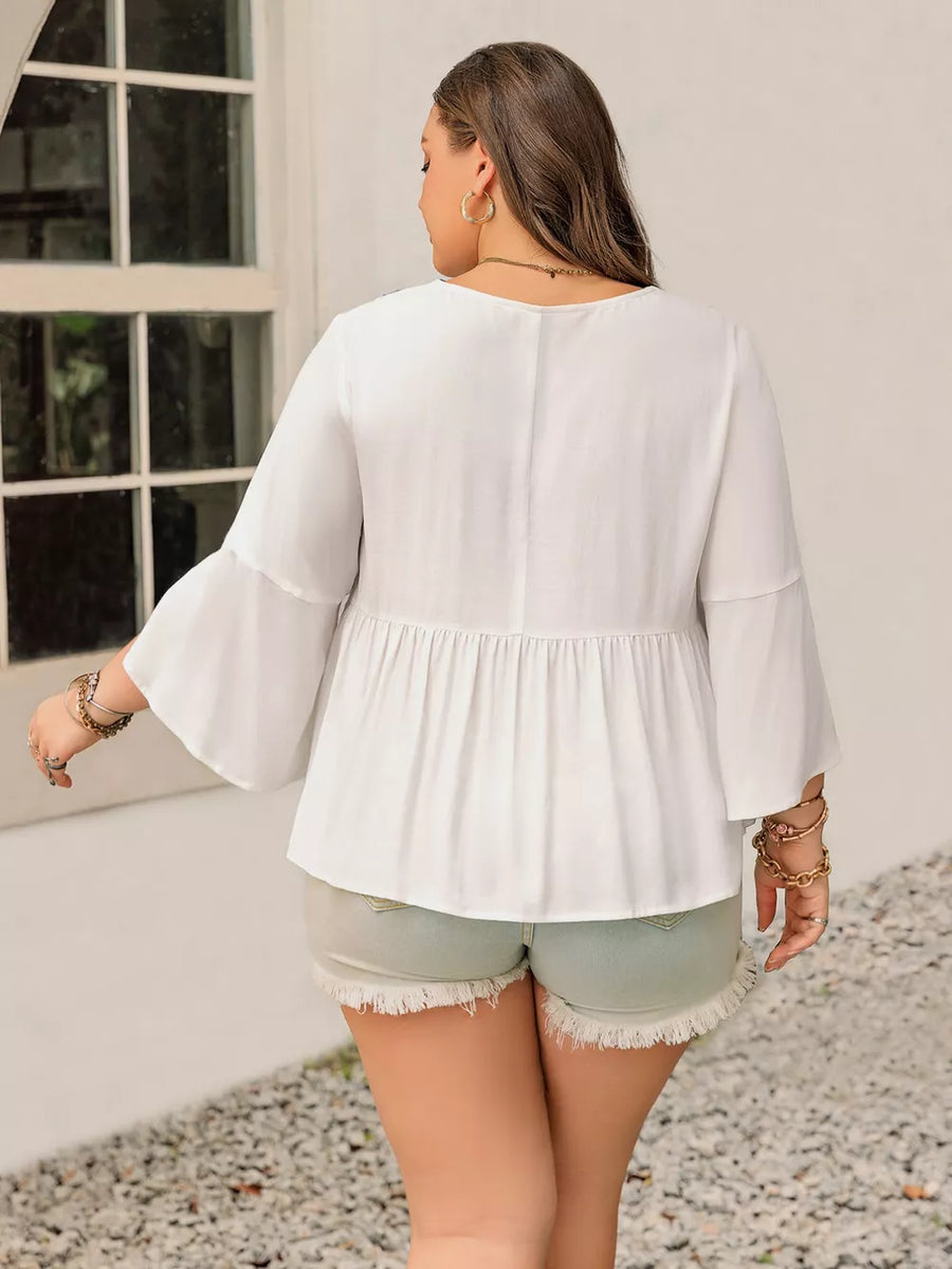 Plus size white peasant blouse with bell sleeves and tiered hem.