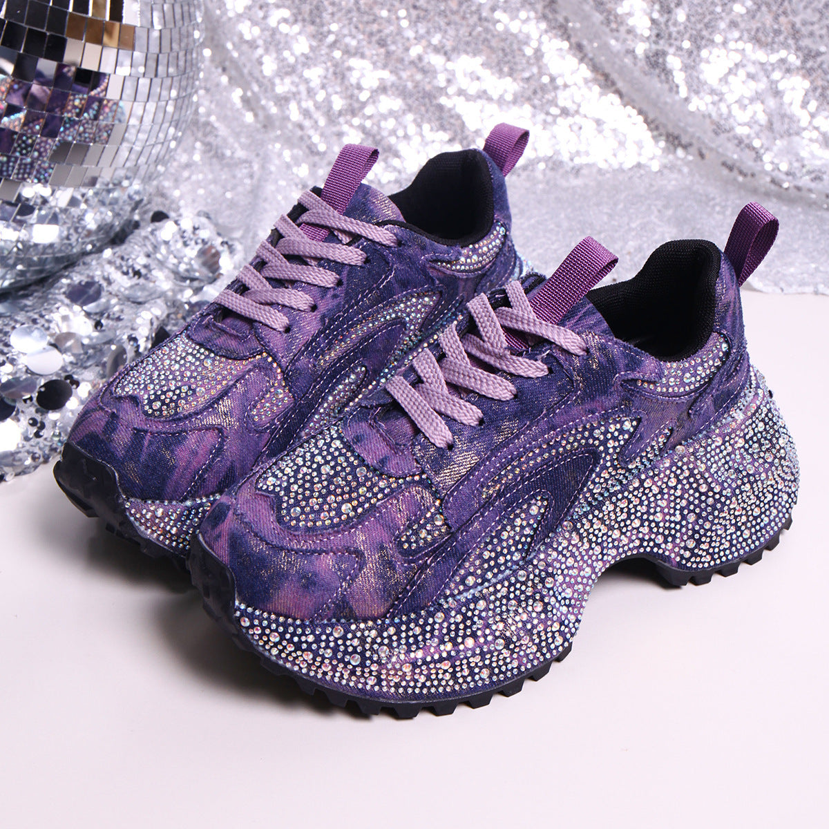 Purple rhinestone platform sneakers with tie-dye pattern and chunky sole.