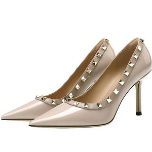 Apricot patent leather pumps with pointed toe and gold stud detail.
