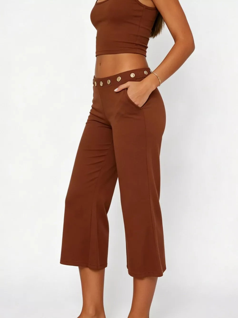 Dark brown flared hem capri pants with button detail and pockets.