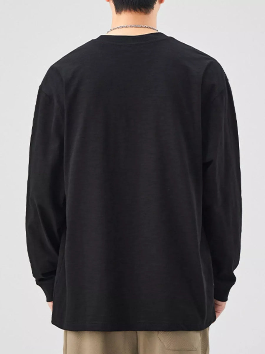 Oversized black cotton long-sleeve tee with crew neck, relaxed fit.