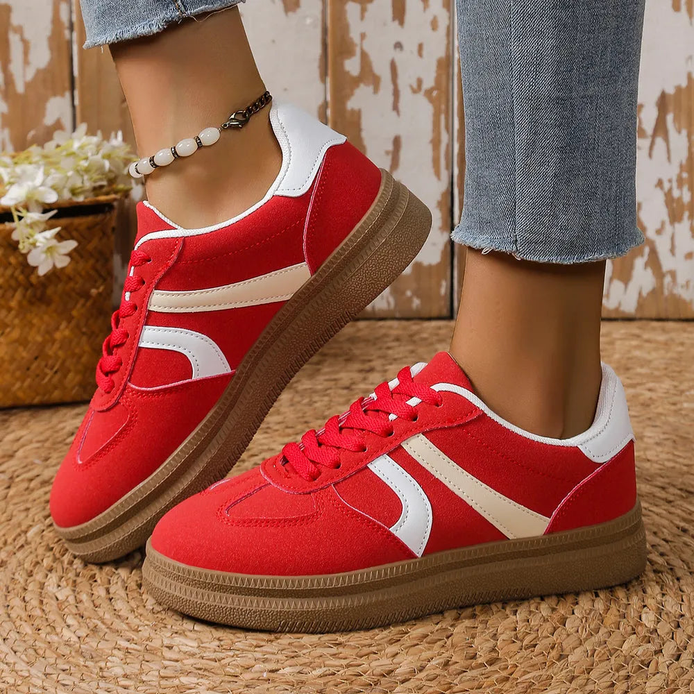 Red suede platform sneakers with curved stripes and white accents.